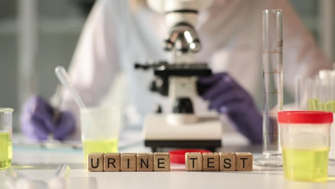 科学家在实验室用显微镜分析尿液