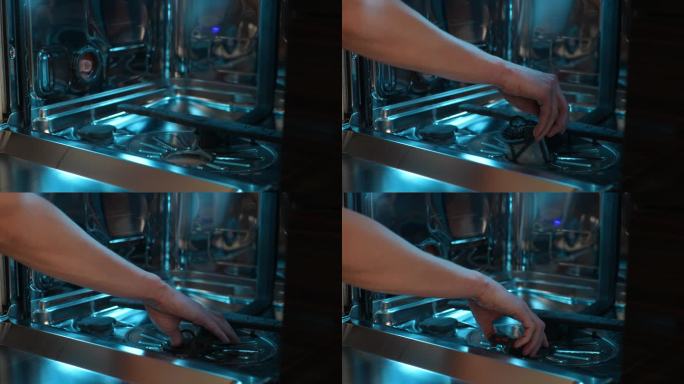 近距离镜头，不知名的维修技师在清洗后将滤网插入洗碗机的水箱内，慢镜头。