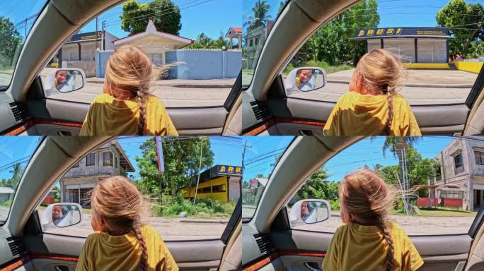 一个女孩从一辆正在行驶的汽车里望向窗外，风吹乱了她的头发
