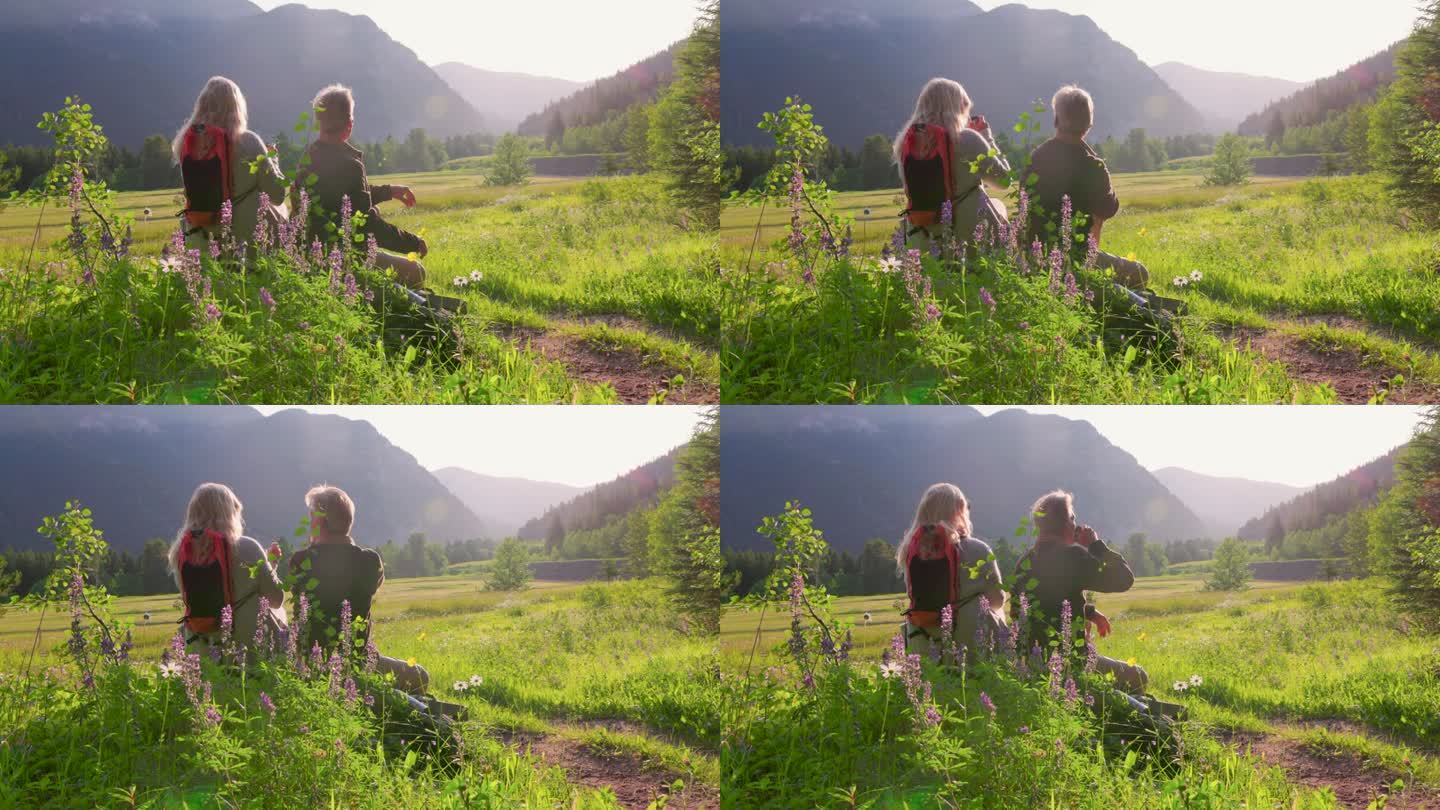 一对徒步旅行的老年夫妇在山上的草地上休息