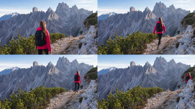 健康的女人征服山路，周围是令人敬畏的山峰