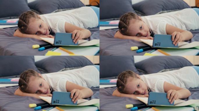 孩子躺在床上用智能手机看搞笑视频