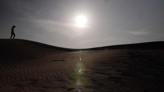 行走在中东沙漠日落中的男子