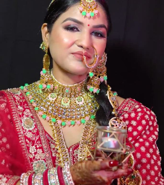 美丽的印度女人穿着新娘的装束，戴着lehanga和珠宝。