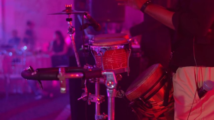 在聚会或音乐会上，男人用手敲鼓。一个没有人脸的视频