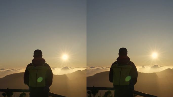 一个人在山上观看金色日落的垂直视频