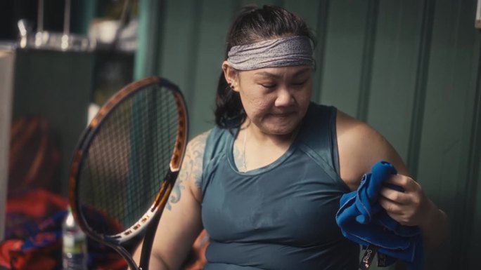 亚洲华人女子网球运动员赛后用毛巾擦汗