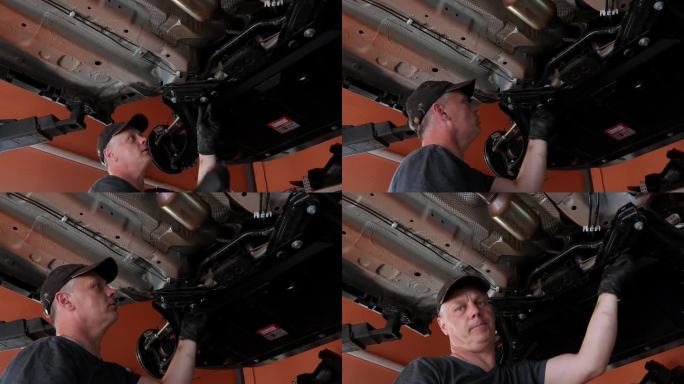 一名汽车维修工人拧紧曲轴箱保护螺栓，修理汽车百余辆