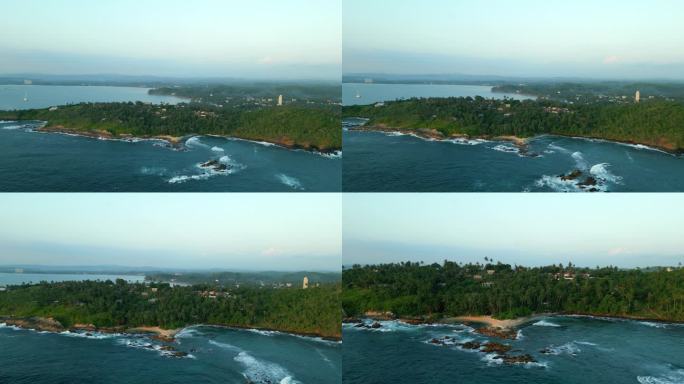 绿色的热带岩石岛在蓝绿色的海洋中间被海浪冲刷垂直鸟瞰。由无人机拍摄的画面显示，斯里兰卡密里萨的秘密海