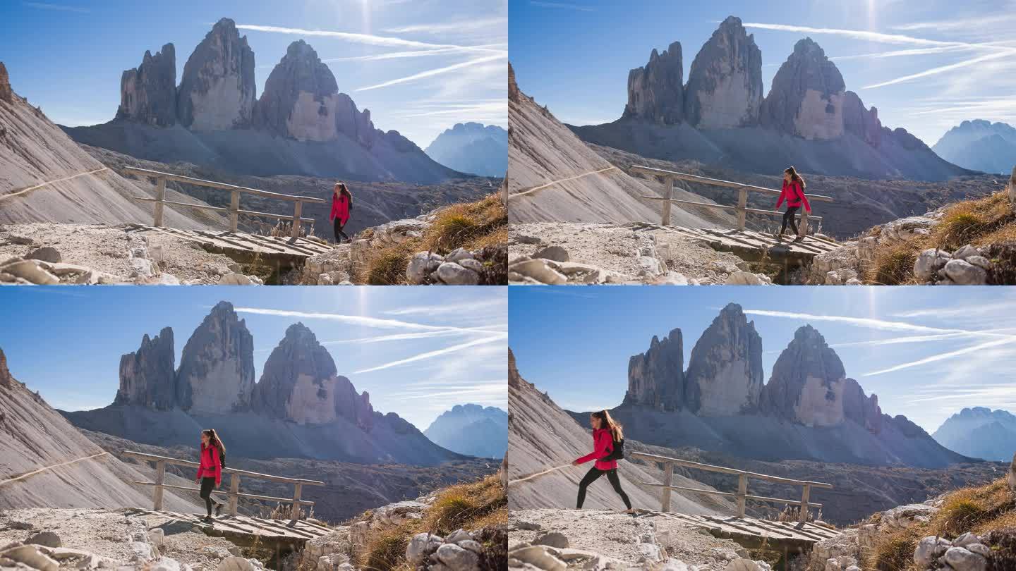 年轻女子征服了山间小道，惊叹于美丽的景色