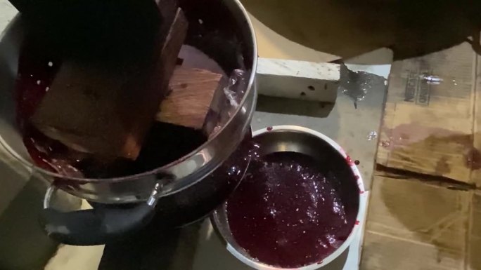 从当地酿酒厂的压榨机中榨出的像血一样粘稠的红色果汁。近距离
