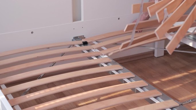 用床板完成一个新的床架。木床底座。矫形外科豪华新床的床架。