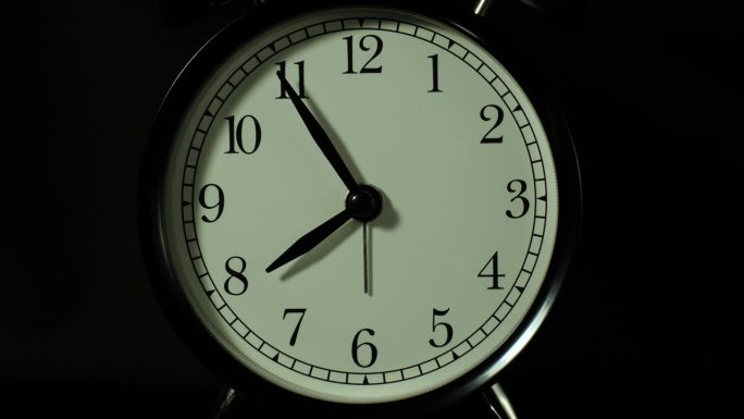 闹钟在黑色背景上，在延时视频的风格。