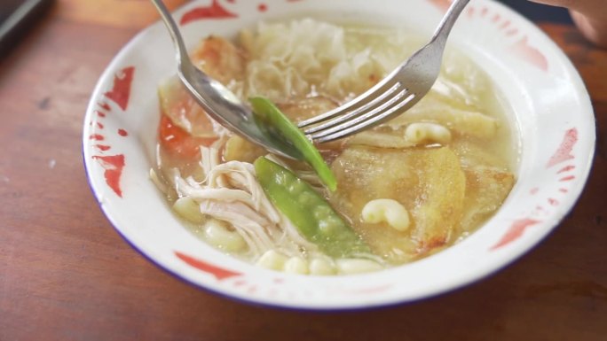 吃印尼的“sop manten”，当地的汤食物，由土豆、鸡肉和各种配料制成