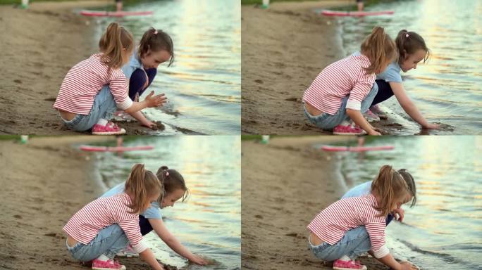 傍晚夕阳下，女孩们在夏日公园的河岸上玩沙。