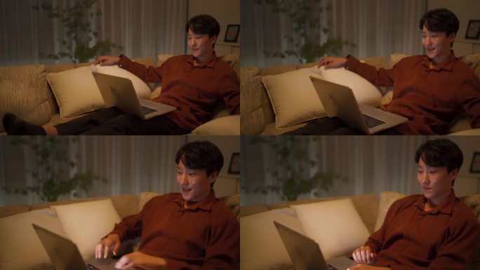韩国帅哥躺在家里的沙发上，用笔记本电脑在网上看放松的视频。年轻人与创作者联系，留下令人鼓舞的反馈意见