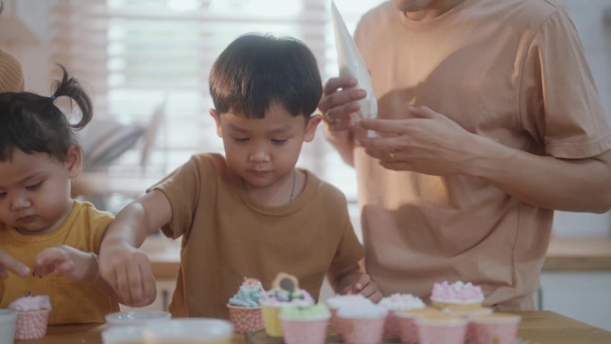 家庭自制的幸福:亚洲家庭在他们的厨房里烹饪甜蜜的回忆。