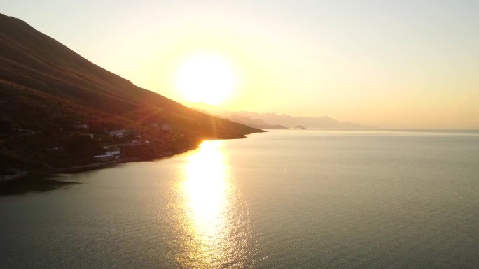 Shkoder附近的日落时，无人机拍摄的Shiroka湖。阿尔巴尼亚。朝山上太阳的方向拍