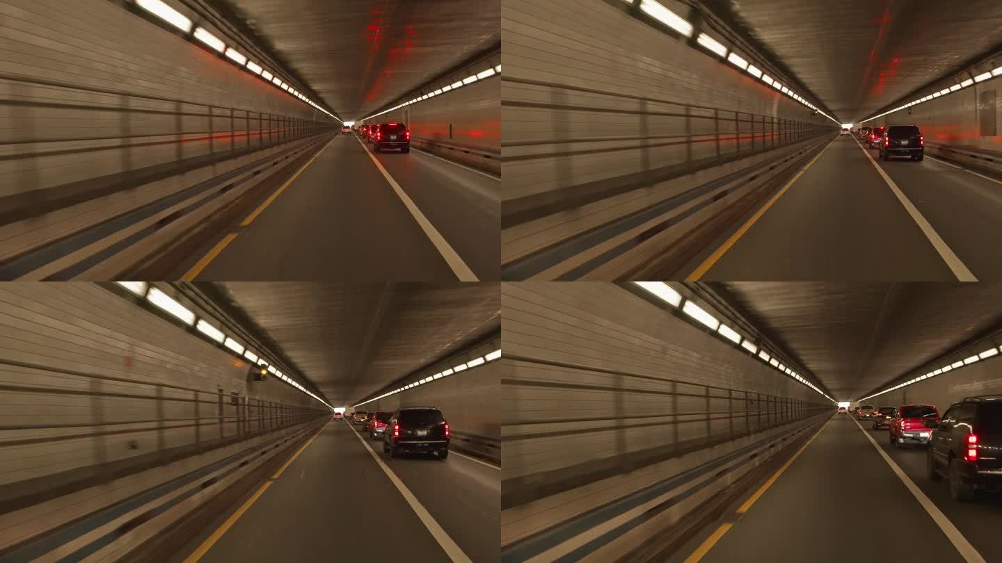 隧道尽头的光明。汽车驶过弗吉尼亚州的汉普顿路大桥隧道。驾驶牌照，POV汽车司机