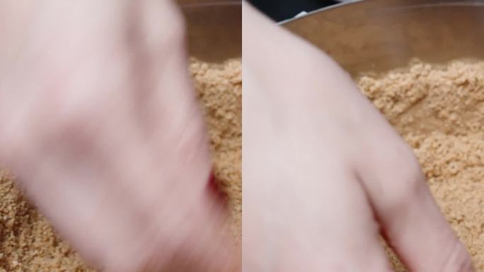 一名妇女用手将压碎的饼干分发到芝士蛋糕模具中。垂直视频社交