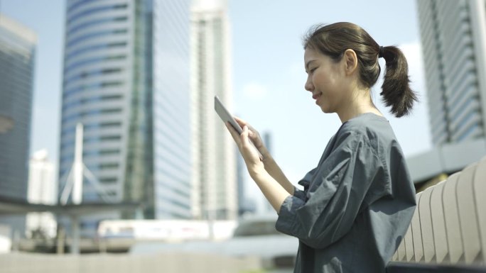 4K年轻女子在金融区使用数码平板电脑