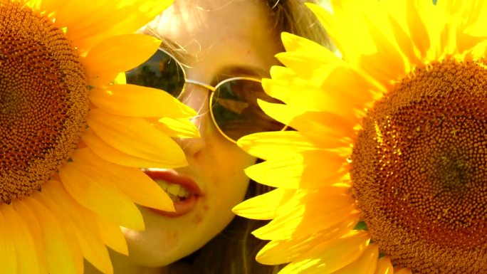年轻女子躲在向日葵花后面唱歌