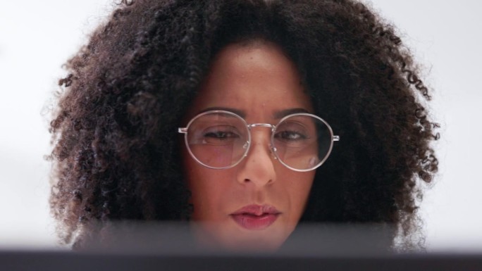严肃的女人，眼镜和面部识别笔记本电脑用于研究，在线分析或数据管理。专注于电脑工作的女性，策划网站信息