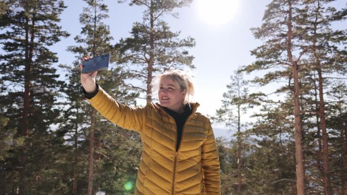 寒假期间，一名女子在森林里用手机自拍