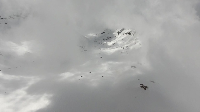 透过云层的雪山斜坡的鸟瞰图