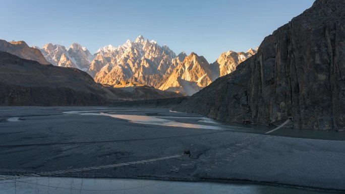 在巴基斯坦北部罕萨山谷地区的帕苏山谷的春天，喀喇昆仑山脉雪山的壮丽景色的延时移动光影日落场景