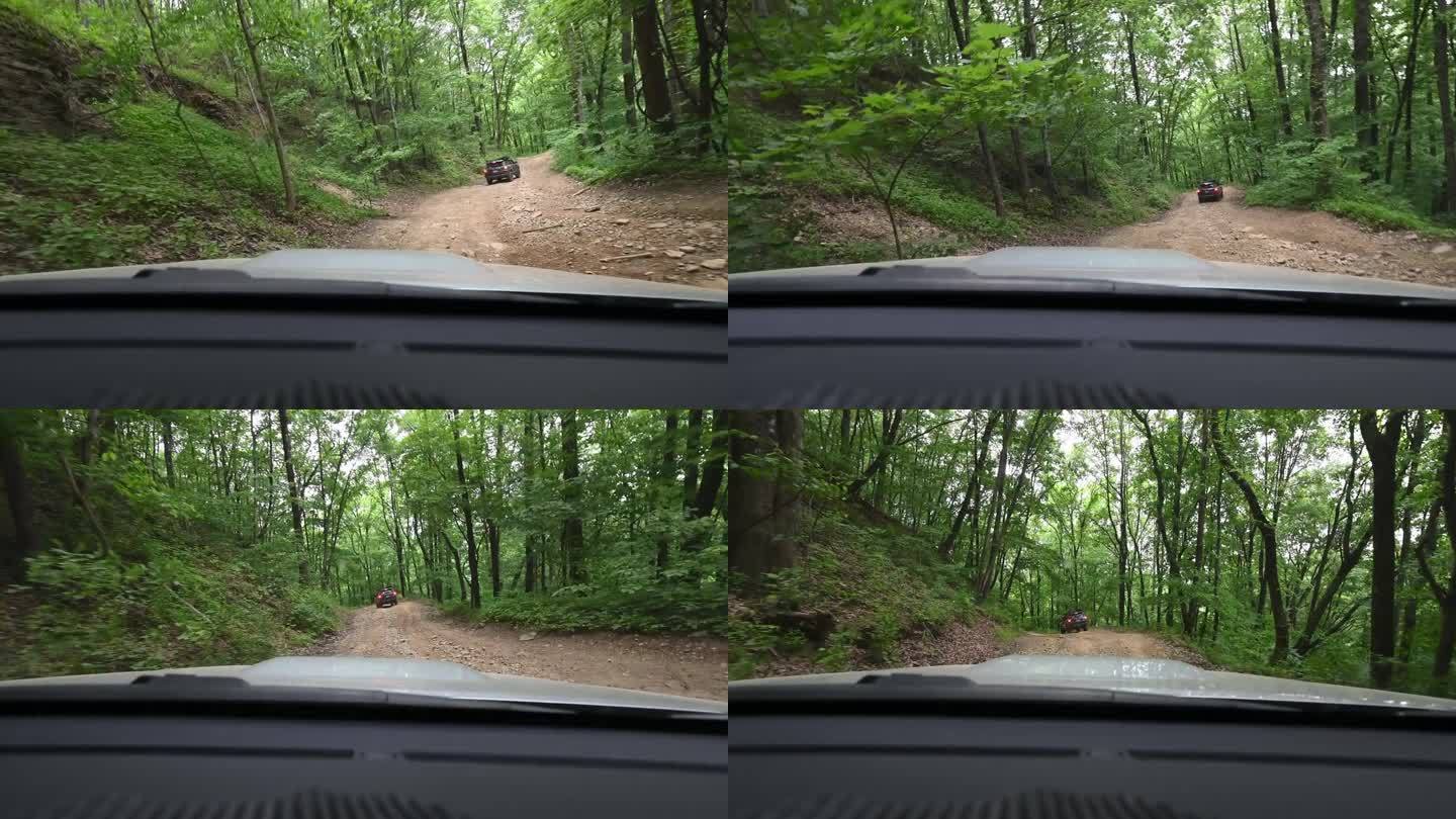 两辆越野车开在森林里的岩石路上