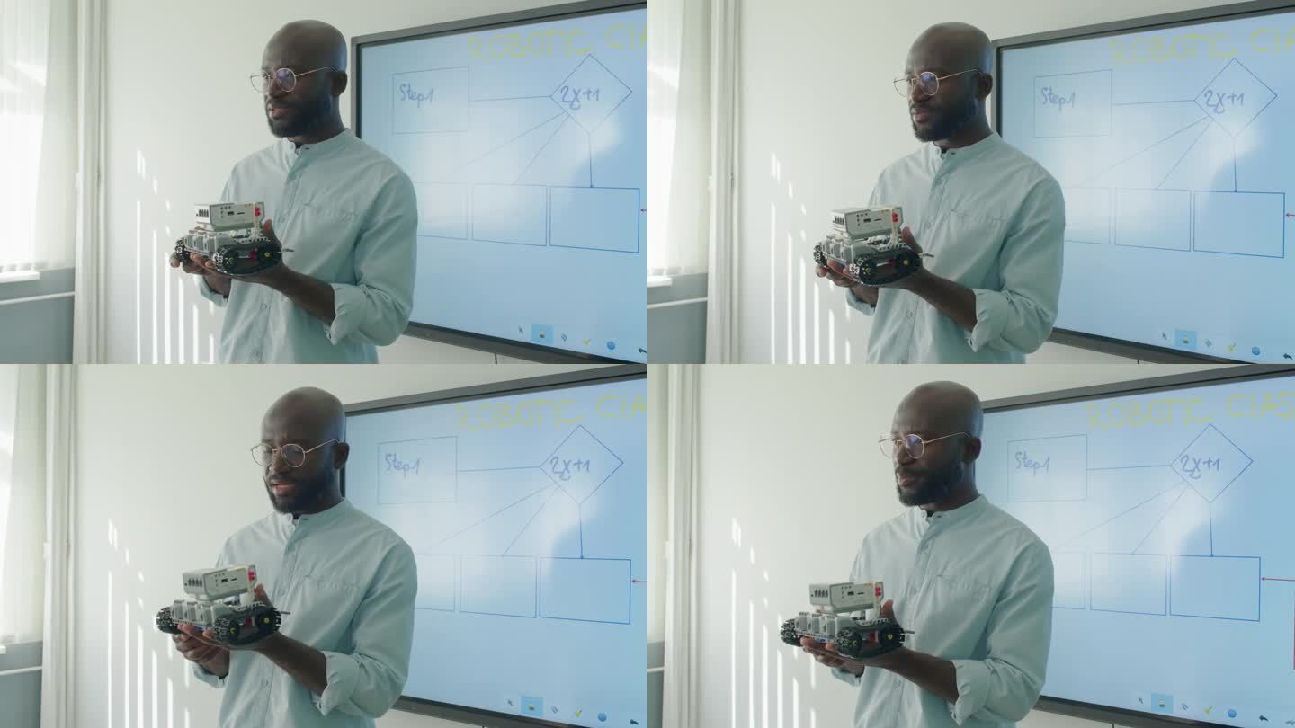 黑人男教师在科学课上拿着机器人说话