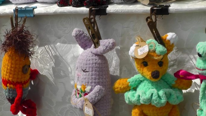 柔软的手工编织玩具挂在柜台的架子上