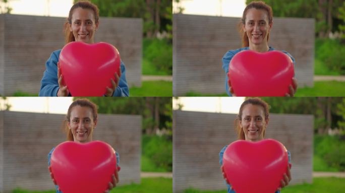 一个手里拿着红心气球的快乐女人的肖像。情绪积极的女孩调情。情人节