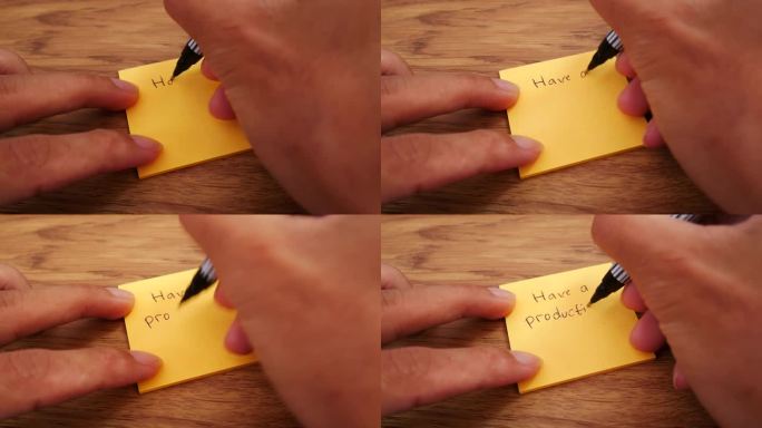 励志视频语录有一个富有成效的一天!一个人在一张木桌上写了一张黄色的纸条。除了花瓶里的绿色植物装饰。