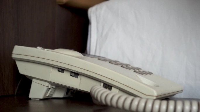 酒店客人拿起电话握住并拨打电话号码。酒店卧室有固定电话。酒店电话服务理念