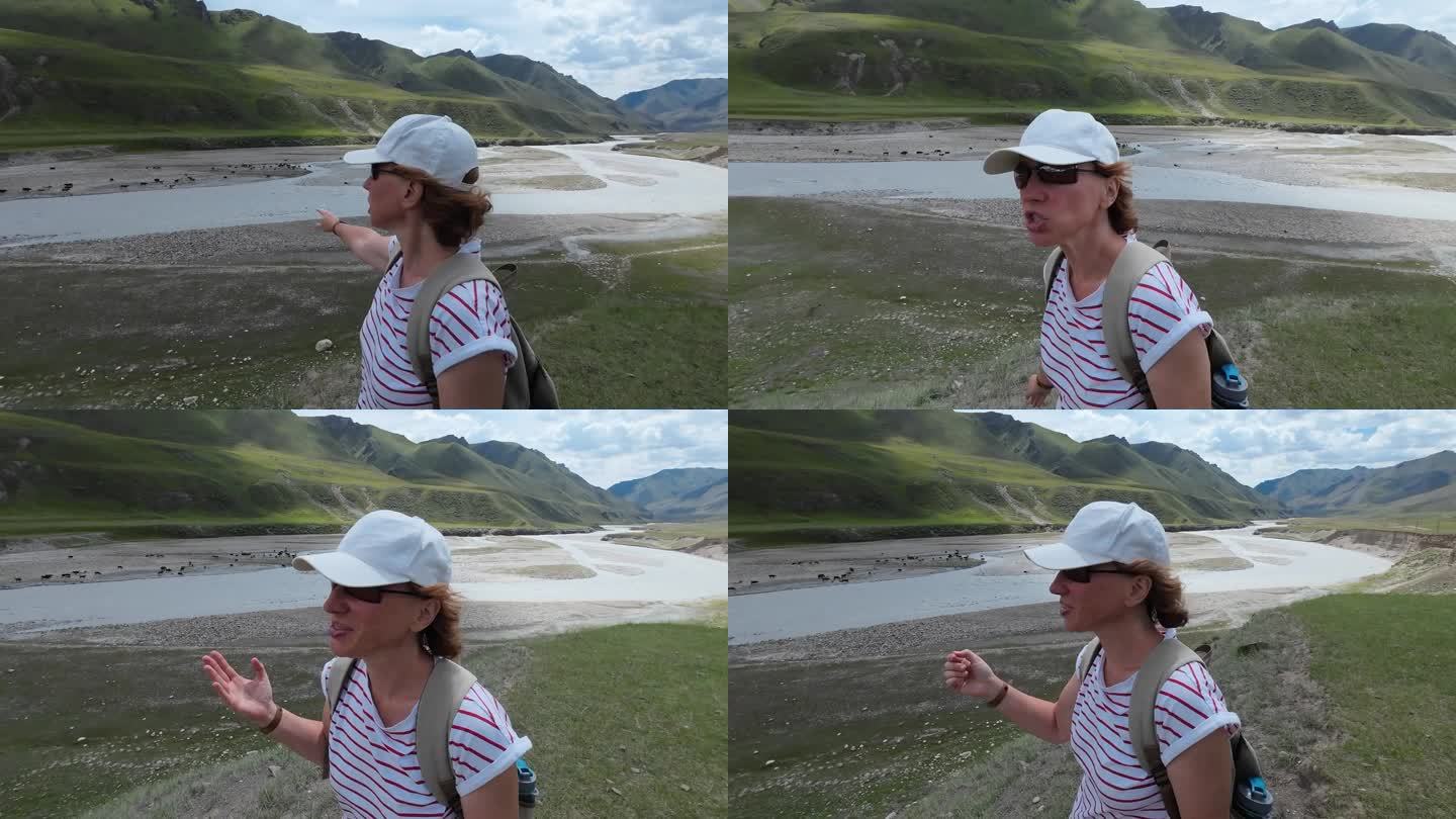 一位兴高采烈的女游客正在用视频记录她在Saryjaz河谷的旅行。自拍的观点