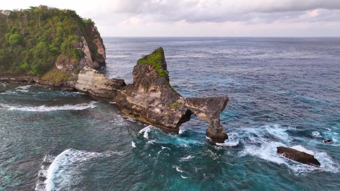 空中无人机日出场景的岩石悬崖在阿图海滩。美丽的大自然努沙Penida在巴厘岛，印度尼西亚。旅游暑假的