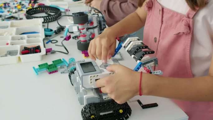 匿名女孩按电动机器人模型按钮的手