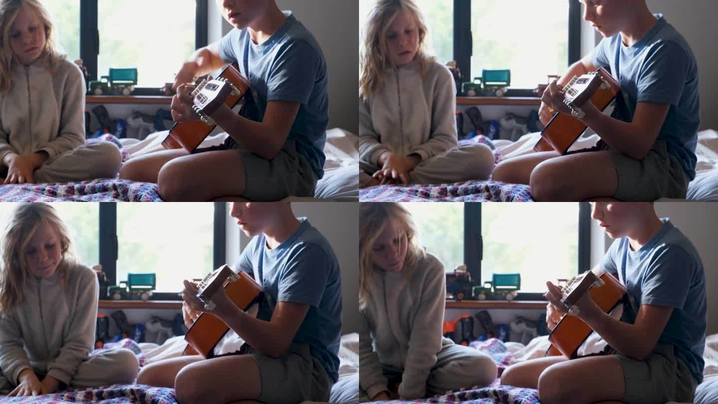 男孩在家里学弹吉他