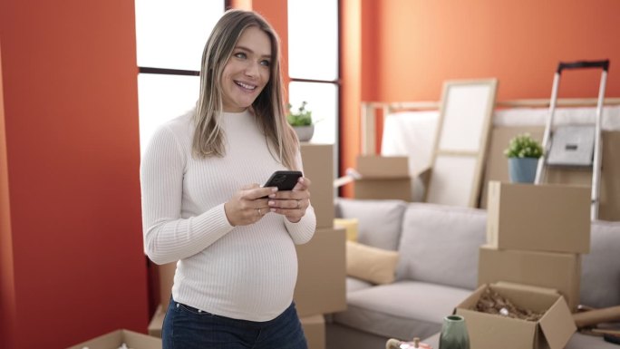 年轻孕妇站在新家使用智能手机