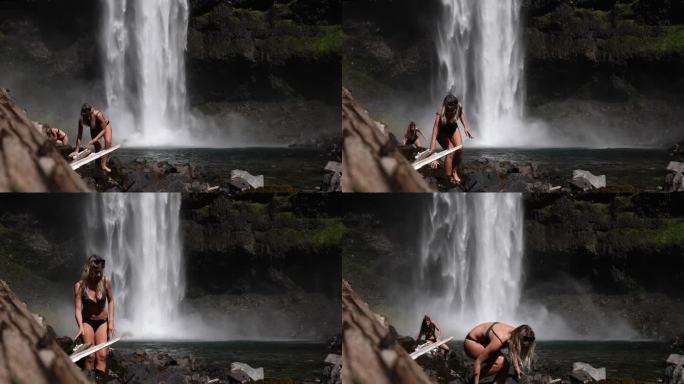 两个年轻女子仰望高耸的瀑布