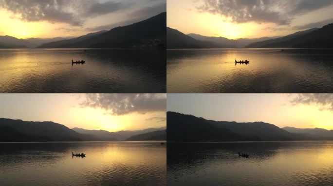 无人机在尼泊尔费瓦湖上空飞行，壮丽的日落与山景。在船上演奏乐器挂鼓。