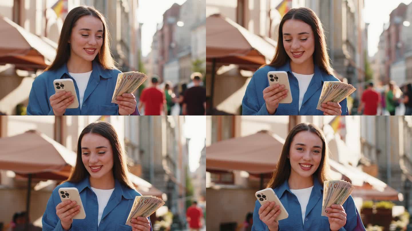 快乐的年轻女子在城市街道上用智能手机计算应用程序数钱