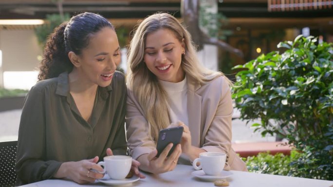 朋友、咖啡店和女人在午餐时间一起在餐馆或咖啡馆用手机谈论社交媒体上的八卦。同事，员工和人们在讨论互联