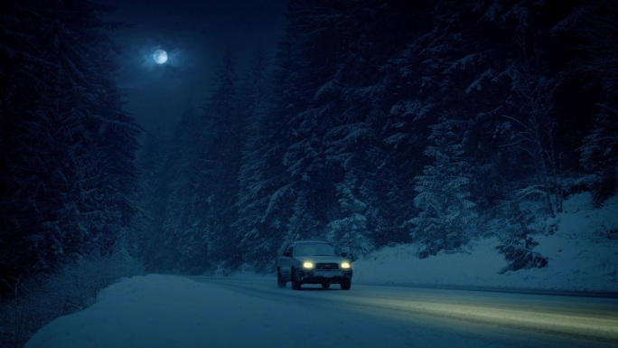 夜晚雪山路上的汽车