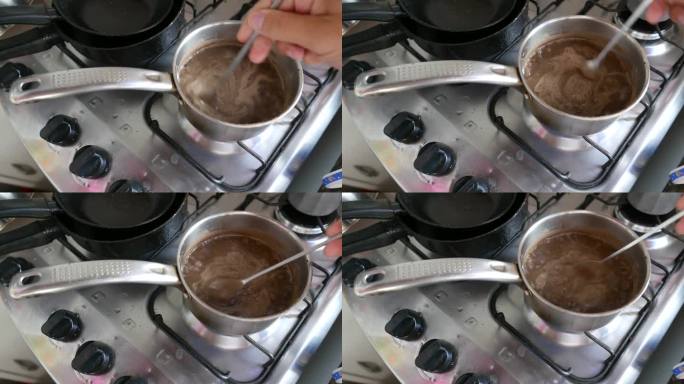 POV:用长勺在小锅里搅拌豆子的人。炉子上热气腾腾的一锅豆子。准备烤豆。炉子，俯视图。热气腾腾的fe