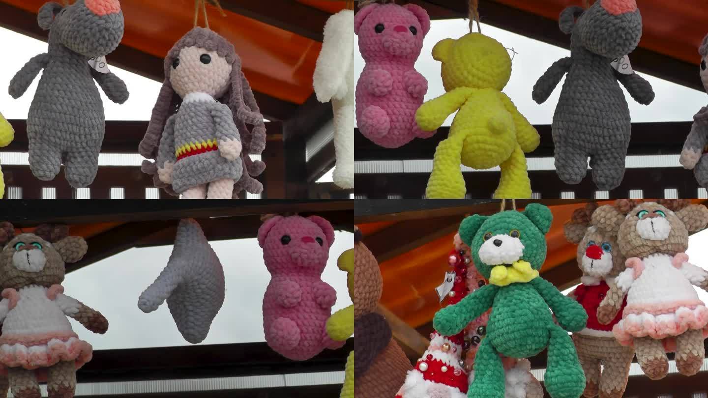 柔软的手工编织玩具挂在柜台的架子上
