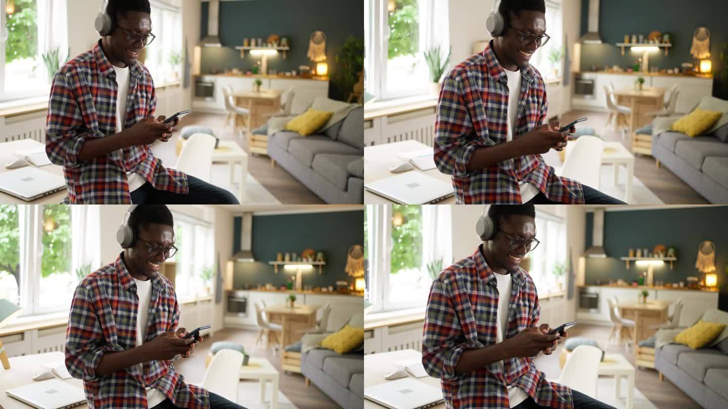 现代非洲裔美国人一边用手机一边用无线耳机听音乐