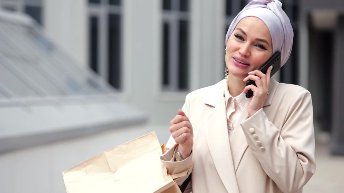 穆斯林女商人通过智能手机与女友通话